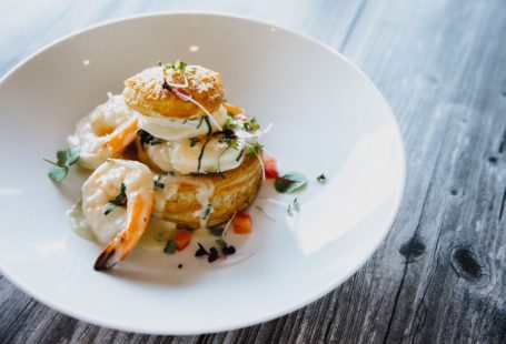 French Cuisine - a white plate topped with food on top of a wooden table