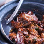 Ayurvedic Cuisine - meat with sauce in black bowl