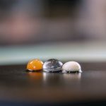 Molecular Gastronomy - three marbles sitting on top of a wooden table