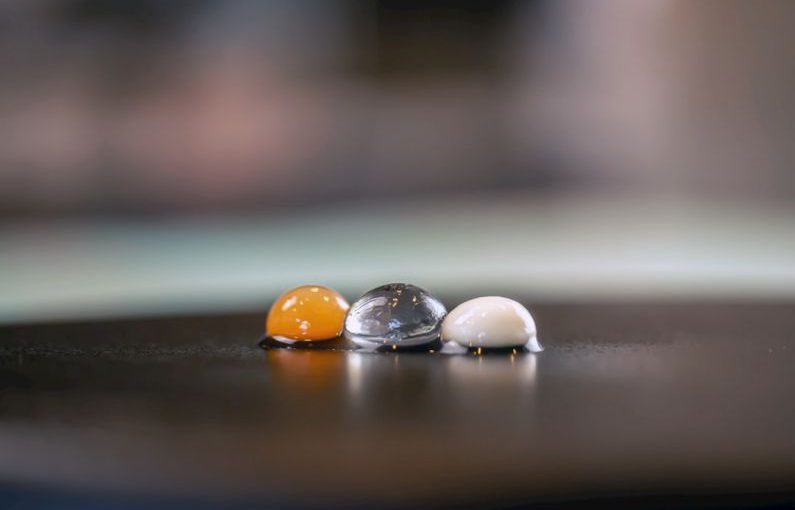 Molecular Gastronomy - three marbles sitting on top of a wooden table