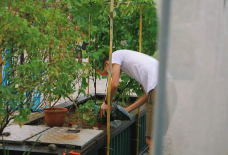 Urban Farming - man in white t-shirt and white pants holding brown wooden stick