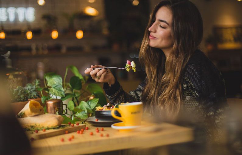 Mindful Eating - woman holding fork in front table
