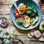 Mediterranean Diet - poached egg with vegetables and tomatoes on blue plate