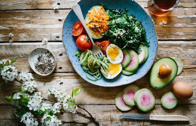 Mediterranean Diet - poached egg with vegetables and tomatoes on blue plate