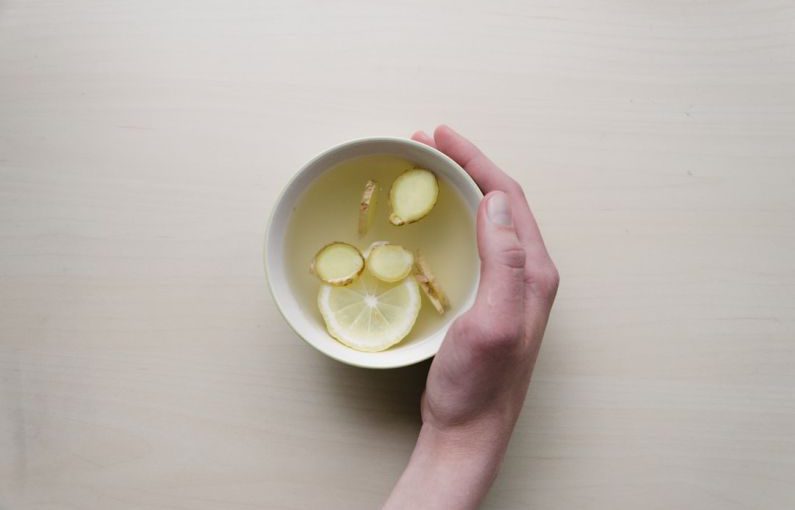 Low FODMAP Food - person holding white bowl with sliced lime and ginger inside