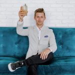 Blockchain Food - man in gray blazer raising drinking glass while sitting on sofa