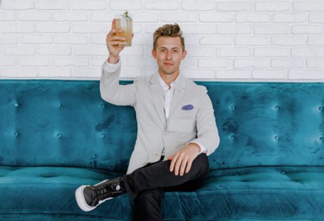 Blockchain Food - man in gray blazer raising drinking glass while sitting on sofa