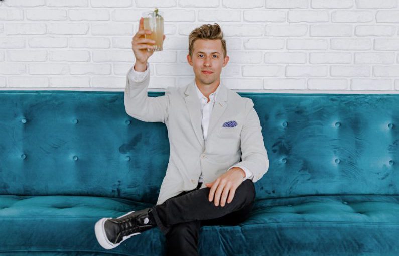 Blockchain Food - man in gray blazer raising drinking glass while sitting on sofa