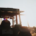 Digital Farming - silhouette of man riding tractor