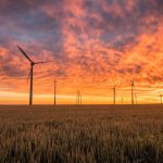 Climate Change Agriculture - landscape photography of grass field with windmills under orange sunset